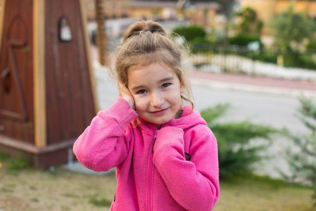 little girl pink hoodie with sad tearful face is holding her ear ear pain otitis media swelling cheek gums toothache children s surgery otolaryngology children s medicine