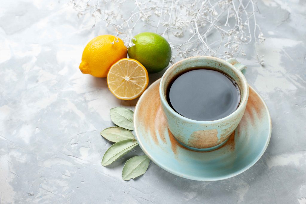 front close view cup tea with fresh lemons white desk fruit fresh citrus exotic
