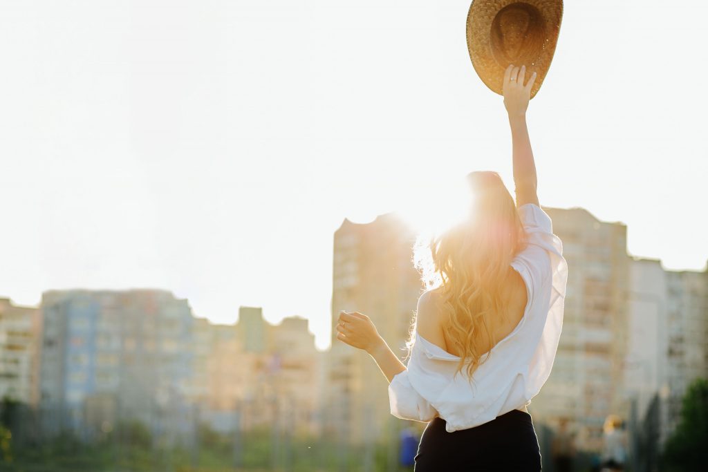 lifestyle freedom concept young pretty woman enjoying warm weather holding straw hat space text